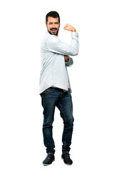Full-length shot of Handsome man with beard doing strong gesture over isolated white background