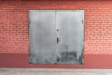 Brick facade with a gray metal gate.