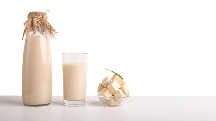 Bottle and glass of soy milk and tofu cheese portion