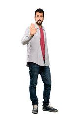 Full-length shot of Handsome man with beard making stop gesture over isolated white background