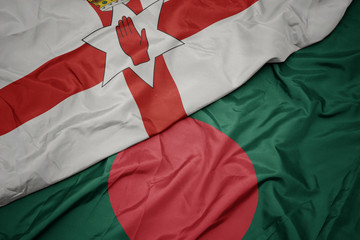 Obraz premium waving colorful flag of bangladesh and national flag of northern ireland.