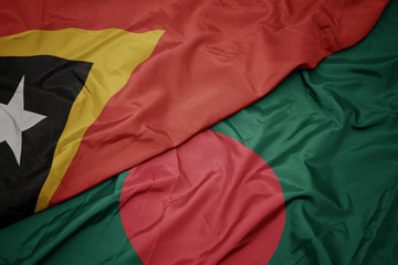 waving colorful flag of bangladesh and national flag of east timor.