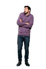Fototapeta premium Full-length shot of Handsome man with sweatshirt making doubts gesture while lifting the shoulders over isolated white background