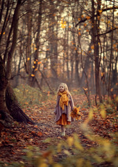 Girl walking in an autumn park with yellow leaves