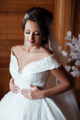 Beautiful bride wearing fashion wedding dress with luxury delight make-up and hairstyle. Sexy bride. Morning of beautiful bride. Bride's fees.