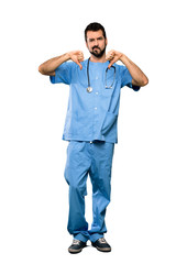 Full-length shot of Surgeon doctor man showing thumb down over isolated white background