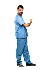Full-length shot of Surgeon doctor man pointing back over isolated white background