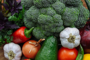 Raw, ripe and juicy vegetables broccoli, onion, garlic, hot pepper, bell pepper, avocado and a bunch of parsley and oregano, health food