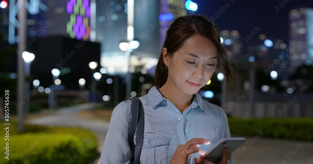 Wall mural woman use of mobile phone in city at night