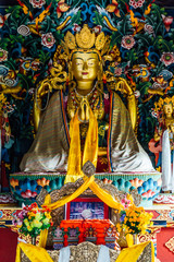 Golden Lord Buddha statue in Bhutanese style inside The Royal Bhutanese Monastery in Bodh Gaya, Bihar, India.
