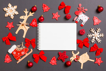 Christmas black background with holiday toys and decorations. Top view of notebook. Happy New Year concept