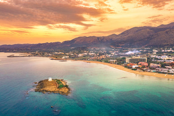 An old white church in a small island at sunset in Malia, Crete, Greece.