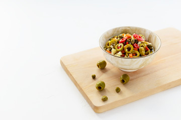 Olive salad for muffuletta in a bowl on a white table.