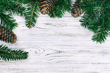 Christmas wooden background with fir tree and pine cone. Top view, copy space. Toned