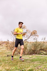 young man running across the field in a Spartan race