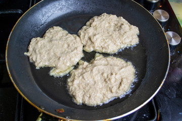 Fried potato pancakes, boiling oil, top view, selective focus, blur background