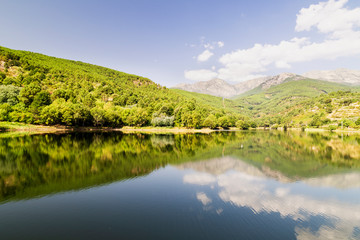 beautiful panoramic view of a lake surrounded by green mountains