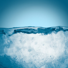 Textured hoary ice block surface on blue background with copy space.