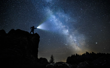 brave guy in night mountains alone with flashlight - obrazy, fototapety, plakaty