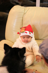 Baby with Santa hat sitting on the sofa