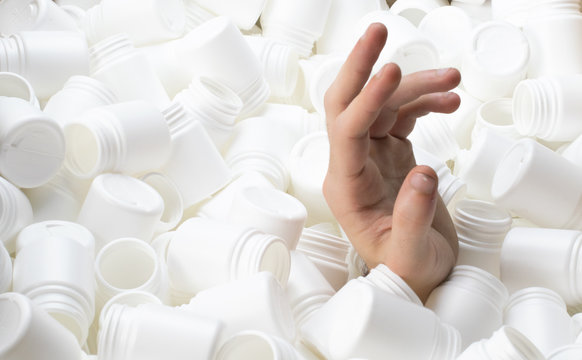 Hand coming out asking for help from a lot of plastic containers