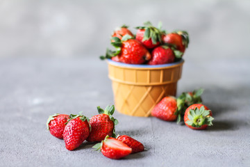 Photo of heap of fresh strawberries in the bowl on rustic grey background..A bunch of ripe strawberries in a bowl on the table. Copy space. Healthy fresh fruit. Organic food. Clear food
