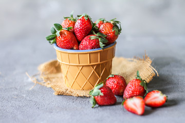 Photo of heap of fresh strawberries in the bowl on rustic grey background..A bunch of ripe strawberries in a bowl on the table. Copy space. Healthy fresh fruit. Organic food. Clear food
