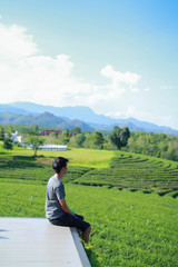 Fototapeta na wymiar Back view of young man looking too Choui Fong tea plantation. - Chiang Rai Thailand.