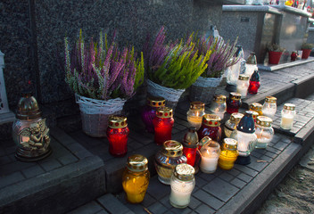 Monument and candles in the cemetery. All Saints Day in Poland. Heather in the cemetery. Flame in the cemetery.