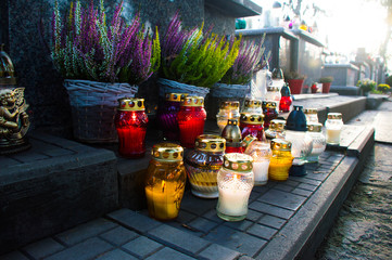 Monument and candles in the cemetery. All Saints Day in Poland. Heather in the cemetery. Flame in the cemetery.