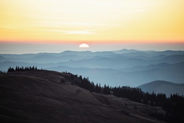 Sunrise landscape with blue layers of Carpathian Mountains,Romania.