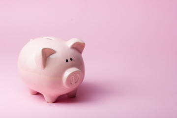 Piggy bank and golden coin. Savings and finance concept