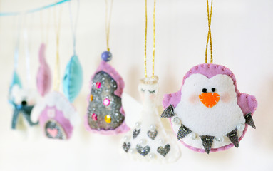 Various Christmas decorations hanging on ribbon
