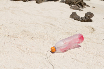 the garbage  plastic bottle was litter on sand beach.