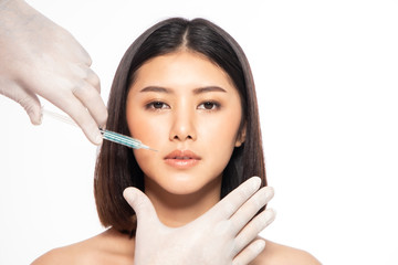 Asain young woman gets injection of botox in her lips. Woman in beauty salon. plastic surgery clinic.Beautiful woman gets botox injection in her face.