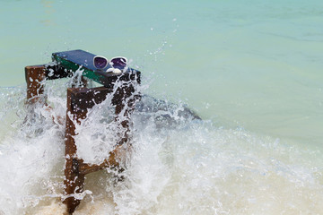 Naklejka premium sunglasses and seashells .And the chair was hit by sea waves. Holiday in summer