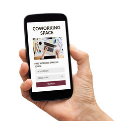 Hand holding a black smart phone with coworking space concept on screen. Isolated on white background.