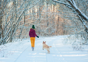 young female woman with dog on winter walk running