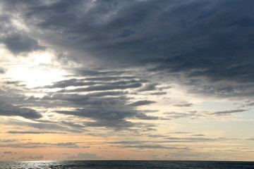Naklejka na ściany i meble Cloudy sunset at the beach 