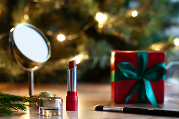 Christmas or New Year beauty concept composition with cosmetics and a gift box. Festive make up...