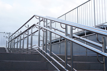 Fototapeta na wymiar Steel handrails of a modern staircase on a city street