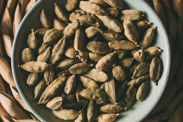 Heap of cardamom seeds in a bowl, close up view. 