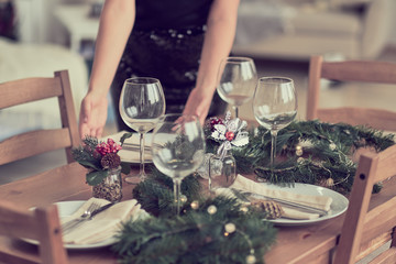 woman is waiting for guests and sets the table. festive laying table, preparation for christmas dinner.