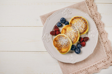 Pancakes with fresh raspberry, blueberries on plate. Healthy breakfast food. Table top view.