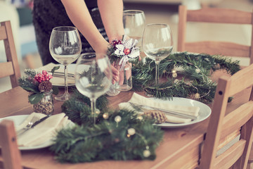 woman is waiting for guests and sets the table. festive laying table, preparation for christmas dinner.