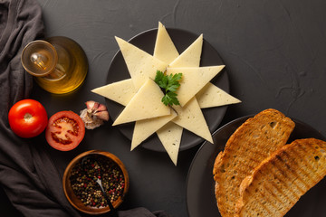 Slices of cheese on black background. Pepper. Aerial View