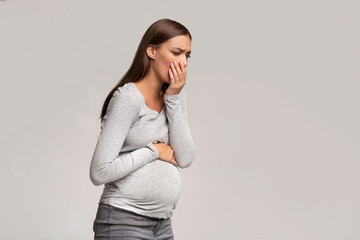 Pregnant Lady Feeling Sick Having Nausea Standing On Gray Background