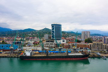 Fototapeta na wymiar Bulk cargo ship under port crane, Batumi seaport, Georgia