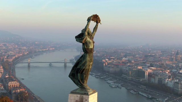 Budapest, Hungary, aerial view of historical landmark Liberty Statue and Budapest cityscape at sunrise.