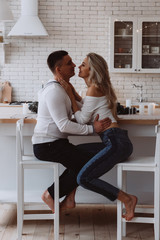 Romantic christmas evening of a young couple. New year love story. Photo session of lovers in the kitchen.